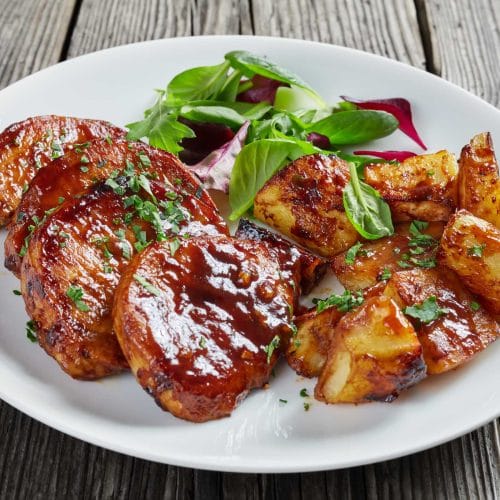 Côtelettes de porc au four servi avec pommes de terres rôties et laitue