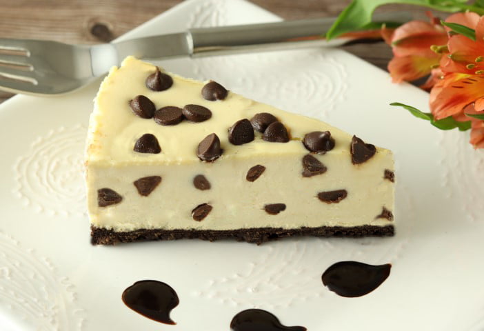 Morceau de gâteau au fromage et aux pépites de chocolat avec coulis de chocolat sur une assiette