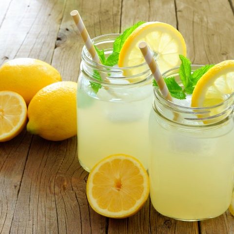 Limonade maison rafraîchissante servie dans deux pots masson garnis de tranches de citron. Une boisson très rafraîchissante.