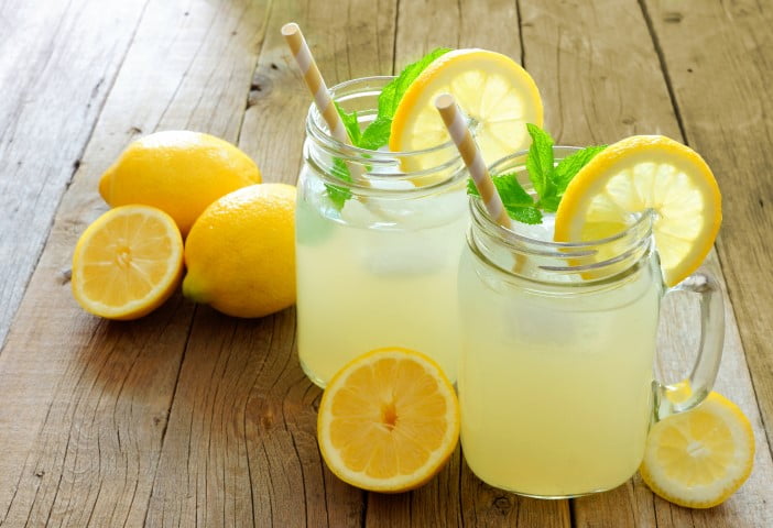 Limonade maison rafraîchissante servie dans deux pots masson garnis de tranches de citron. Une boisson très rafraîchissante.