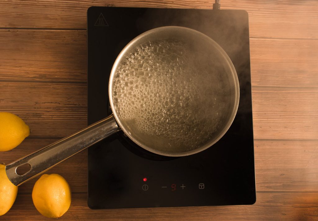 Eau et sucre bouille dans une casserole pour faire un sirop simple