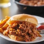 Viande à Sloppy Joe servi sur pain hamburger accompagné de pommes de terre frites