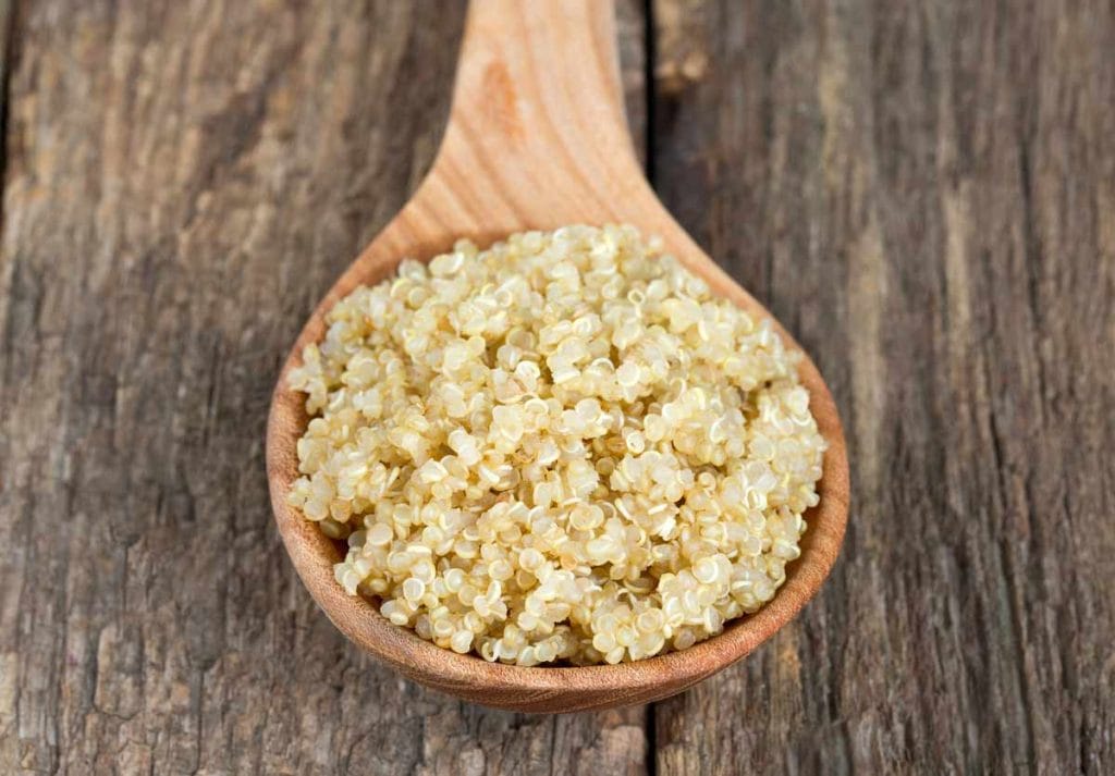 Cuillère de bois contenant des grains de quinoa après la cuisson à l'autocuiseur Instant Pot