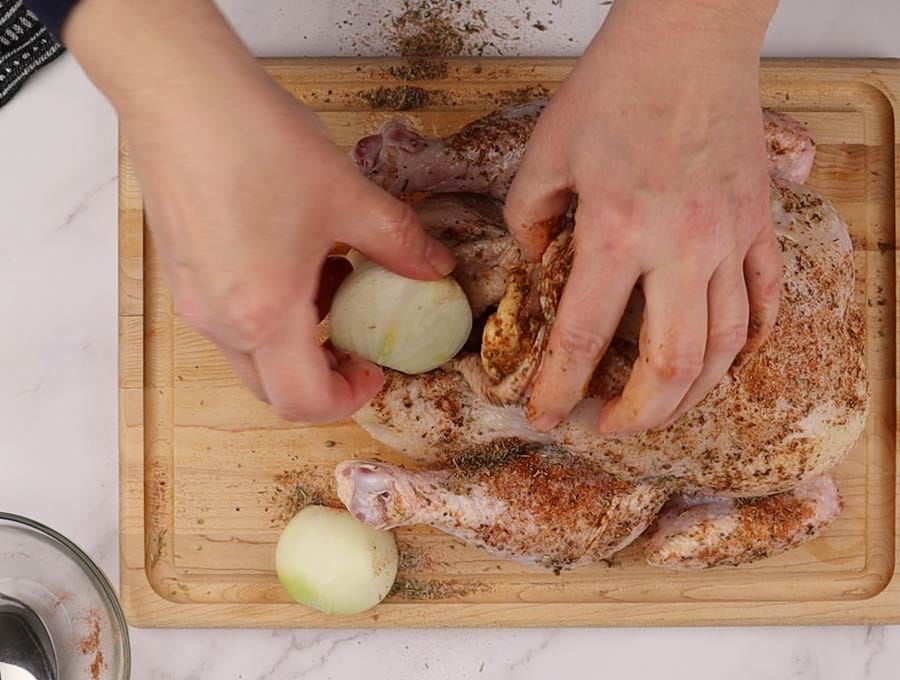 Le poulet est couvert d'épice et dans lequel de l'oignon dans la cavité et prêt pour la cuisson à l'Instant Pot.