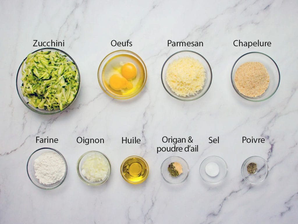 Courgette râpée, oeuf, fromage parmesan, chapelure, farine, oignon, huile et les assaisonnements dans des bols différents en verre clair