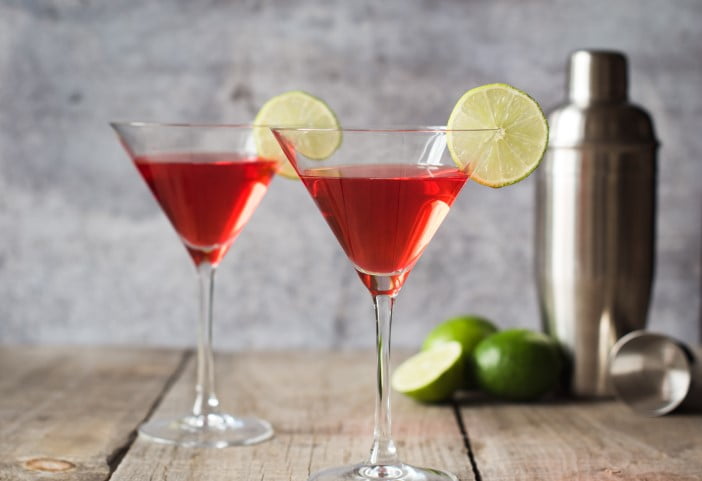 Cocktail cosmopolitan à la vodka, à la liqueur d'orange, au jus de canneberge et jus de lime dans un verre à martini
