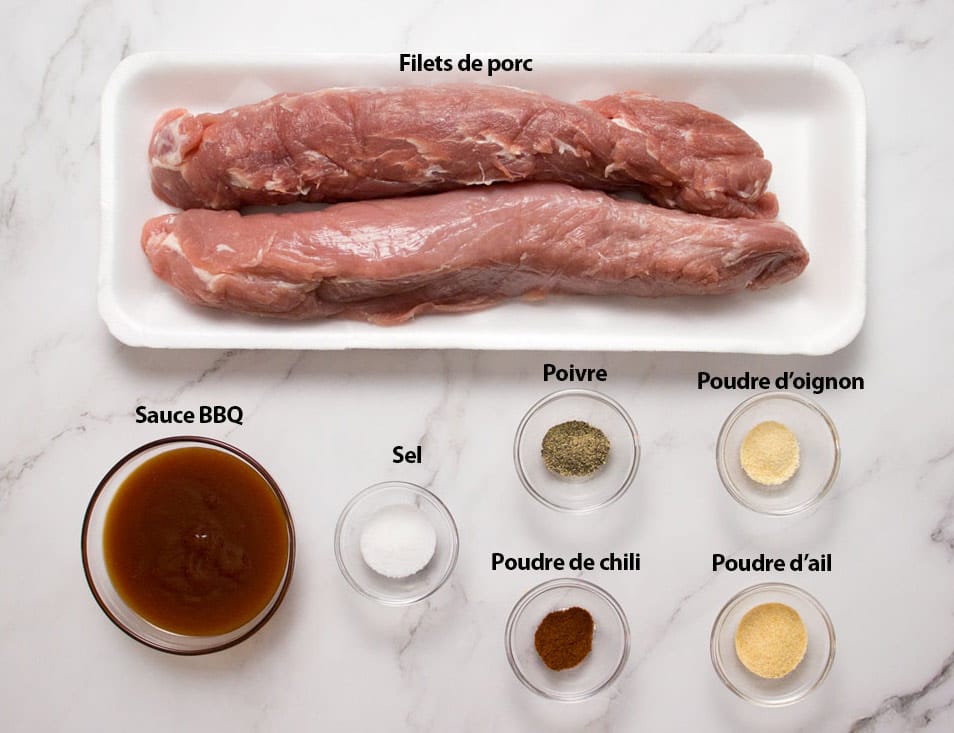 deux filets de porc crus dans son emballage, sauce barbecue, poudre d'ail et d'oignon, poudre de chili, sel et poivre dans des petits bols individuels