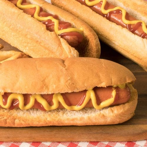 hot-dogs cuits dans la friteuse à air avec moutarde et ketchup sur une planche