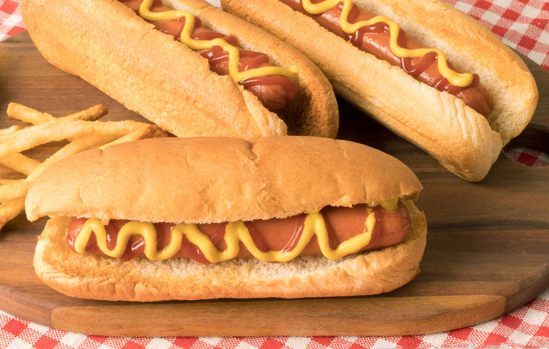 hot-dogs cuits dans la friteuse à air avec moutarde et ketchup sur une planche