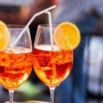 Deux verres de cocktail Aperol Spritz sur glace avec des tranches d'orange en décoration