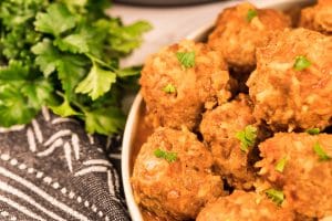 Boulettes porc-épic dans une sauce tomatée fait au Instant Pot servies dans une assiette blanche et accompagnées de tranches de pain