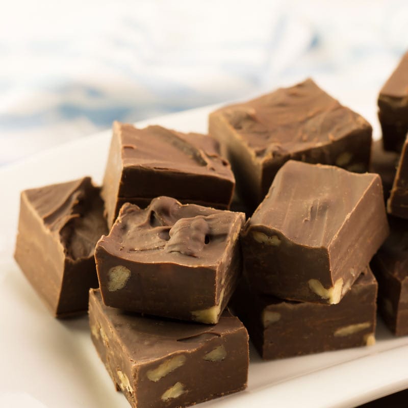 Plusieurs carrés de fudge au chocolat servis sur une assiette blanche