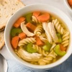 Soupe poulet et nouilles maison à l'autocuiseur Instant Pot servi dans deux bols blanc et accompagné de tranches de pain
