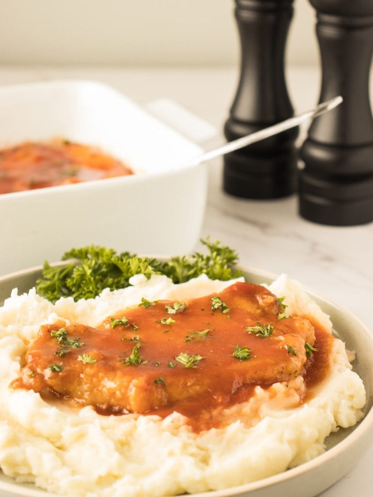 Côtelettes de porc avec une sauce sucrée et salée servie sur une purée de pomme de terre.