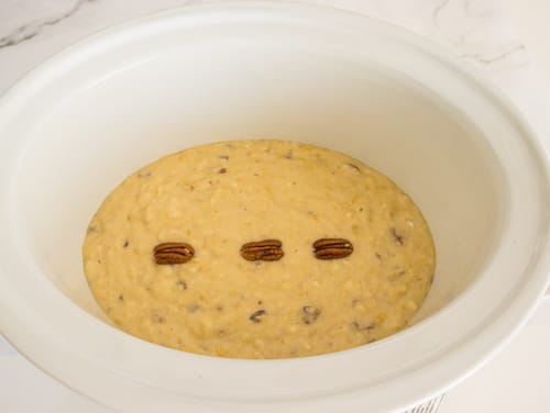 La pâte du pain aux bananes est versée dans le récipient de la mijoteuse.
