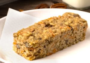 Gros plan d'une barre aux carottes et aux pacanes sur une assiette blanche