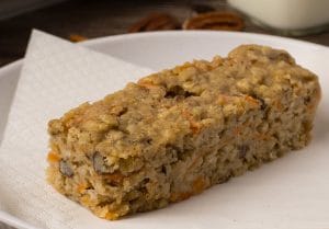 Gros plan d'une barre aux carottes et aux pacanes sur une assiette blanche