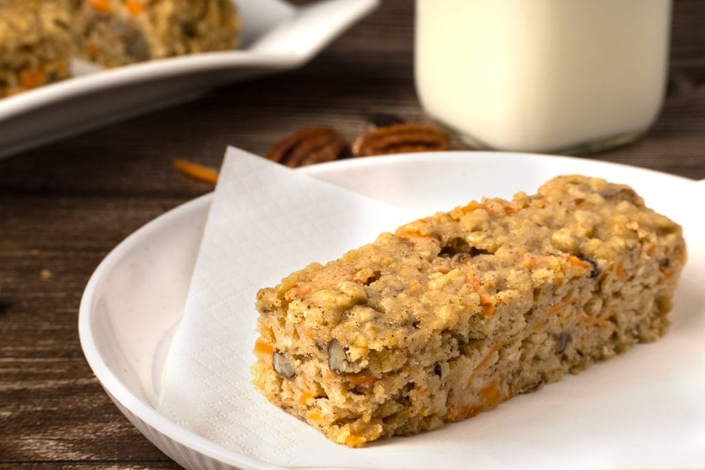 Barre aux carottes sur une petite assiette blanche avec un verre de lait