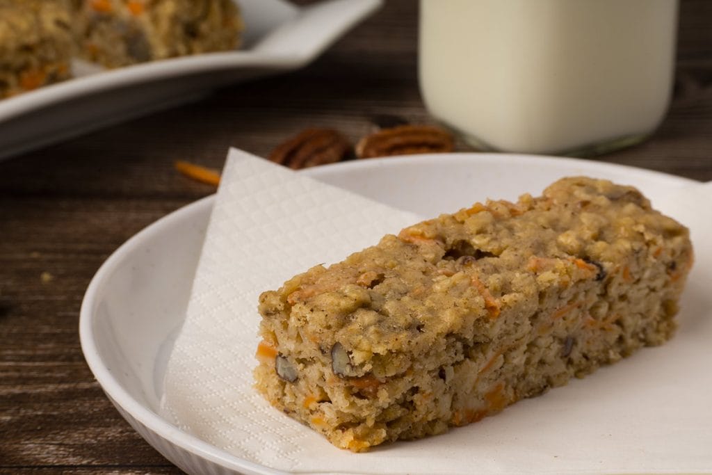 Barre aux carottes sur une petite assiette blanche avec un verre de lait